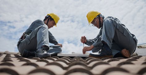 Roofing repair in austin texas, Slanted roof with 2 roofing professionals on roof.